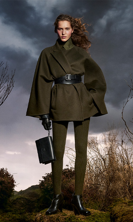 Look Max Mara campagna Untamed Heroine con cappotto corto e leggings color verde muschio e borsa in cuoio.