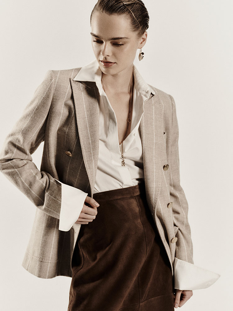 Modella indossa blazer doppiopetto Max Mara Sartoriale Beige in Alpaca e Lana con camicia chiara e pantaloni marroni.